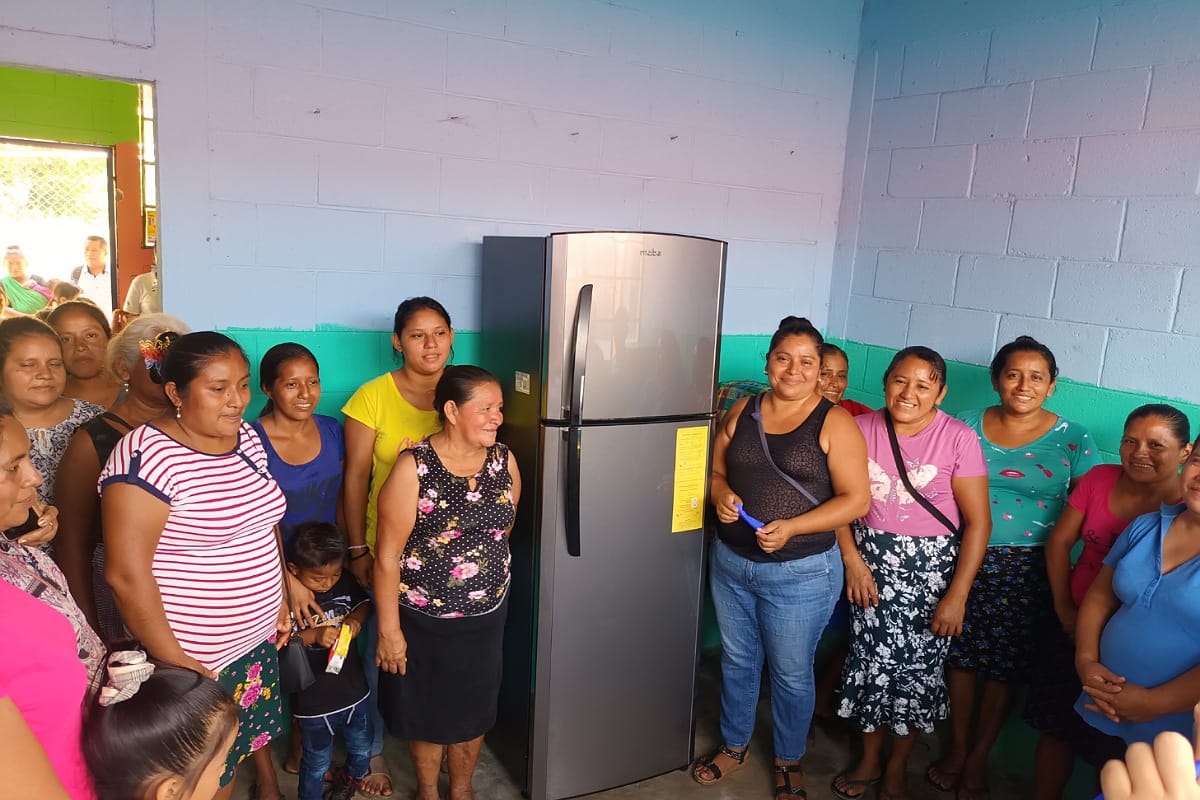 Locals pose in front of the donated refrigerator 