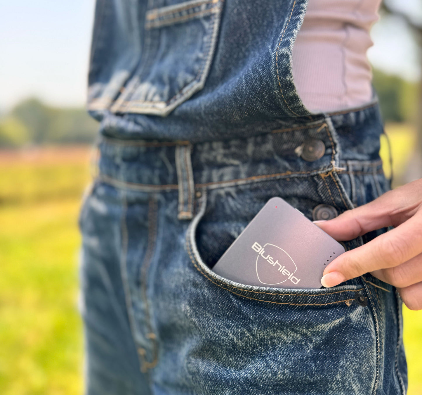 
                  
                    The Ultimate portable peaks out of the pocket of a person's overalls
                  
                
