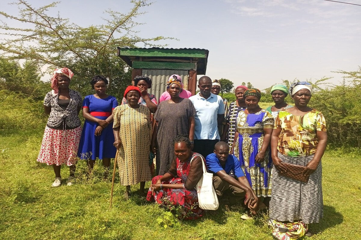 People have their picture taken in front of there old pit latrine toilet
